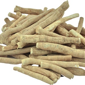 May include: A pile of ashwagandha root pieces, showcasing a light tan color and a rough, textured surface. The roots vary in size and shape, with a natural, organic appearance. The image is set against a plain white background.
