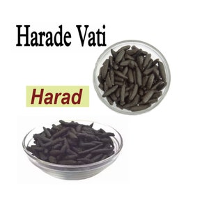 May include: Two bowls filled with black Harad Vati, a type of Ayurvedic herbal medicine. The text "Harad" is written in a yellow box and the text "Harad Vati" is written in black.