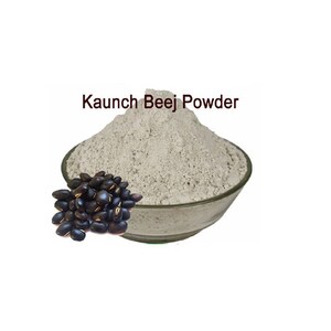 May include: A white bowl filled with light grey Kaunch Beej Powder. A pile of black seeds sits in front of the bowl.