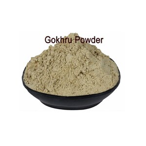 May include: A black bowl filled with a light brown powder labelled "Gokhru Powder".