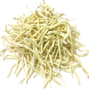May include: A pile of dried, pale yellow lily buds against a white background. The buds are long, thin, and slightly curved, with a textured appearance. The image is a close-up, highlighting the details of the dried flowers.