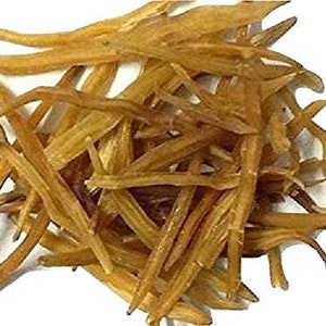 May include: A close-up shot of a pile of dried, light brown, and tan-colored herbs. The herbs have a long, thin, and slightly curved shape, with a rough texture. The background is plain white, highlighting the natural colors and textures of the herbs.