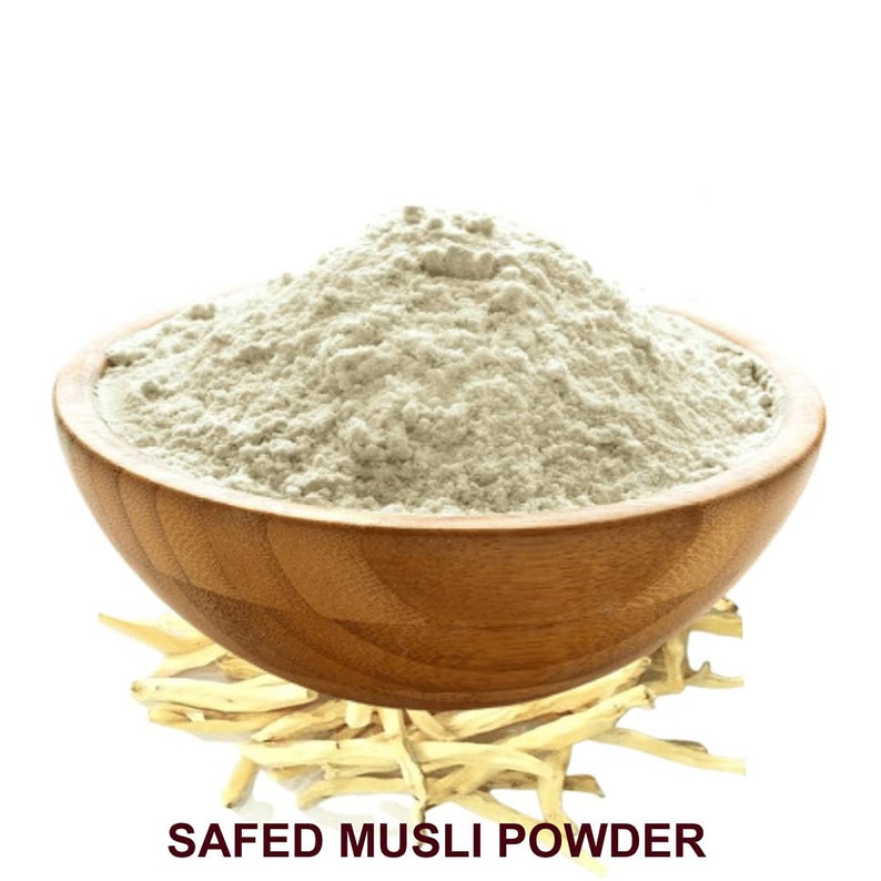 May include: A wooden bowl filled with a light beige powder labeled "Safed Musli Powder". The powder is made from the roots of the Safed Musli plant, which is a popular herb in Ayurvedic medicine.