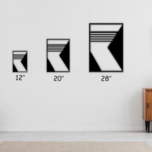 May include: Three black and white geometric wall art prints in different sizes: 12 inches, 20 inches, and 28 inches. The prints feature a stylized design of a white arrow pointing to the right with black stripes.