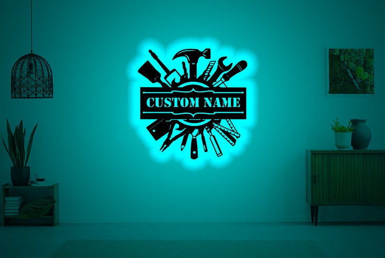 May include: Black silhouette of various tools arranged in a circle with a banner that says "CUSTOM NAME" in the center. The image is on a teal background.