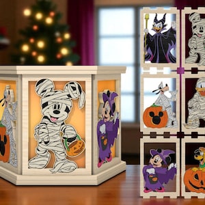 Op de afbeelding: Een houten lichtbak met Halloween-thema met Disney-personages in mummie- en heksenkostuums. De doos heeft een crèmekleurig frame met oranje verlichte panelen. Personages zijn onder meer Mickey Mouse, Minnie Mouse, Donald Duck en Goofy. Een aparte display toont extra karakters.