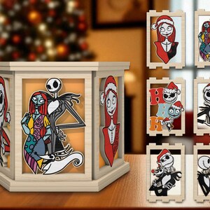 May include: A wooden lantern featuring characters from The Nightmare Before Christmas. The lantern has six sides, each displaying a different character or scene. Additional framed character art is also shown, including Jack Skellington and Sally.