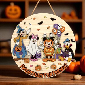 May include: Round wooden Halloween sign featuring Disney characters in costume. Goofy, Minnie Mouse, Mickey Mouse, and Donald Duck are dressed up for Halloween. The sign has the text "FRIGHTFULLY FUN FRIENDS!" and is decorated with pumpkins, bats, and candy.