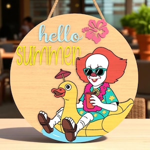 Könnte beinhalten: Runder Holzschild mit den Worten "hello summer" in Blau und Gelb. Das Schild zeigt einen Cartoon-Clown mit Sonnenbrille und einem Getränk, der auf einem gelben Enten-Schwimmer reitet. Oben rechts befindet sich eine rosa Hibiskusblüte.