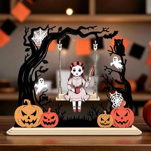Op de afbeelding: Een houten Halloween-decoratie met een pop op een schommel, met een mes en een beker. De scène bevat pompoenen, geesten, vleermuizen en een uil, allemaal in een donkere, griezelige omgeving.