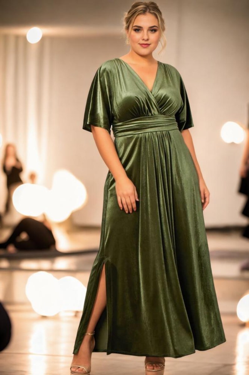 May include: A long, green velvet dress with a V-neckline and a wrap-style bodice. The dress has a side slit and short, wide sleeves.