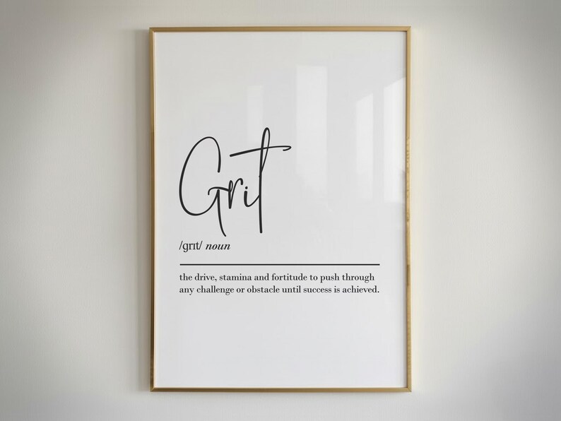 May include: A framed print with the word "Grit" in a stylish script font. Below the word is the definition of grit, describing drive, stamina, and fortitude. The frame is gold, and the background is white.