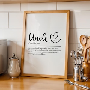 May include: A wooden-framed print featuring the word "Uncle" in elegant script, with a heart symbol. The definition of "Uncle" is printed below. The frame is light brown, and the background is white.
