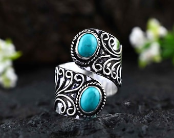 Peut inclure: Bague en argent avec une pierre turquoise sertie dans un motif en spirale.