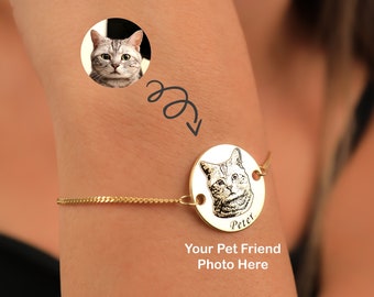 以下が含まれることがあります： 猫の白黒写真が描かれた丸いチャームが付いた金のチェーンブレスレット。チャームには「Peter」という名前が刻まれています。