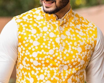 May include: A yellow waistcoat with white floral embroidery. The waistcoat has a mandarin collar and a button closure.