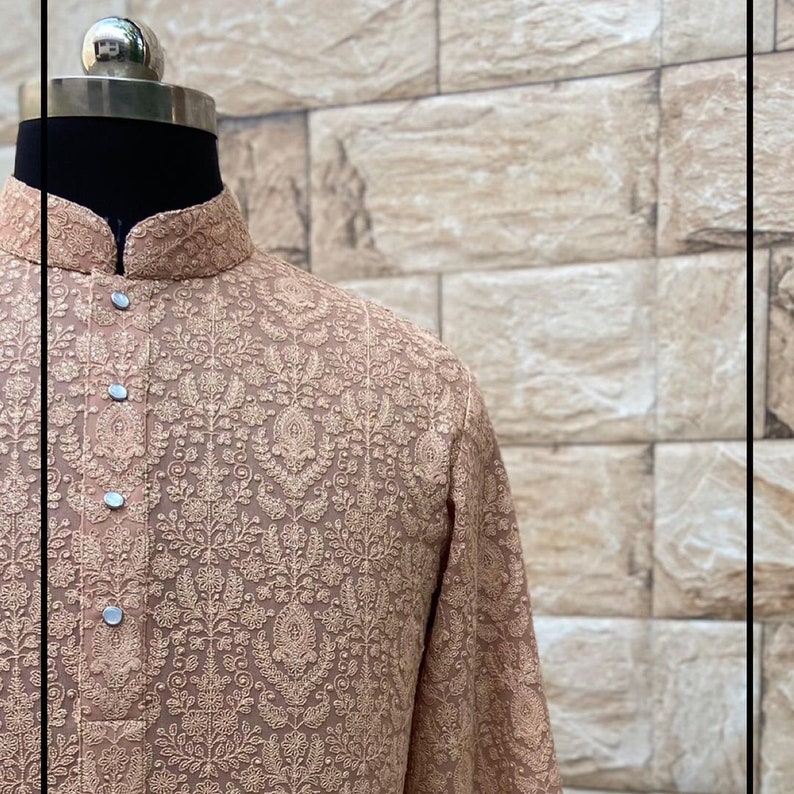 May include: A beige long-sleeved shirt with a floral pattern and button closure.