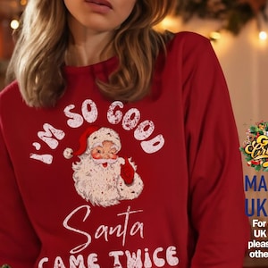 Może przedstawiać: Czerwona bluza z nadrukiem w stylu vintage przedstawiającym Świętego Mikołaja i napisem "I'M SO GOOD Santa CAME TWICE" w kolorze białym. Bluza ma długie rękawy i okrągły dekolt.