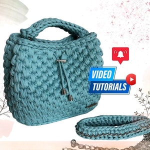 以下が含まれることがあります： シルバーチェーンストラップとドローストリングクロージャーが付いたターコイズ色のクロシェハンドバッグ。バッグの側面には「VIDEO TUTORIALS」のラベルが付いています。