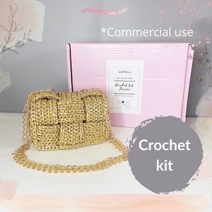 Könnte beinhalten: Eine goldfarbene Häkeltasche mit Kettenriemen. Die Tasche hat ein gewebtes Design und wird mit einer rosa Schachtel mit der Aufschrift "Crochet kit Divina" präsentiert. Ein grauer Kreis mit den Worten "Crochet kit" befindet sich ebenfalls im Bild.
