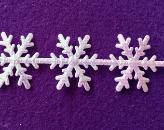 May include: White snowflake trim with a glittery finish. The trim is made of a soft, flexible material and is perfect for adding a festive touch to any craft project.