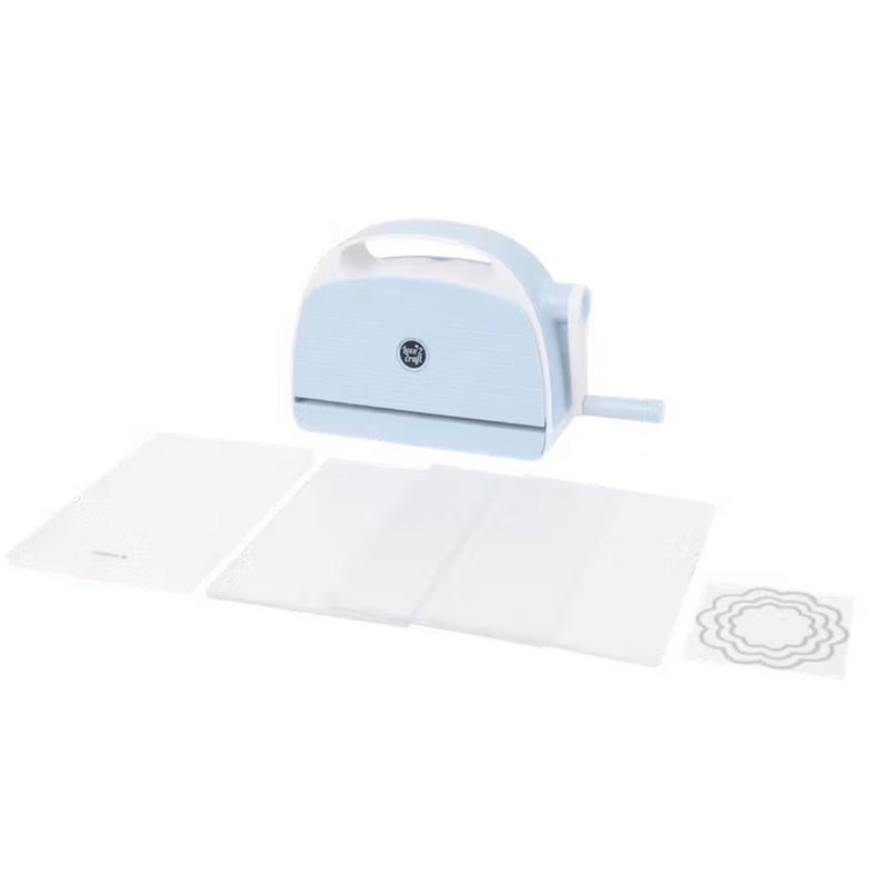 Puede incluir: M&aacute;quina de troquelado y relieve azul claro con asa y manivela blancas. Se incluyen varias placas de pl&aacute;stico transparente y un troquel decorativo. La m&aacute;quina tiene un peque&ntilde;o logotipo en la parte delantera.