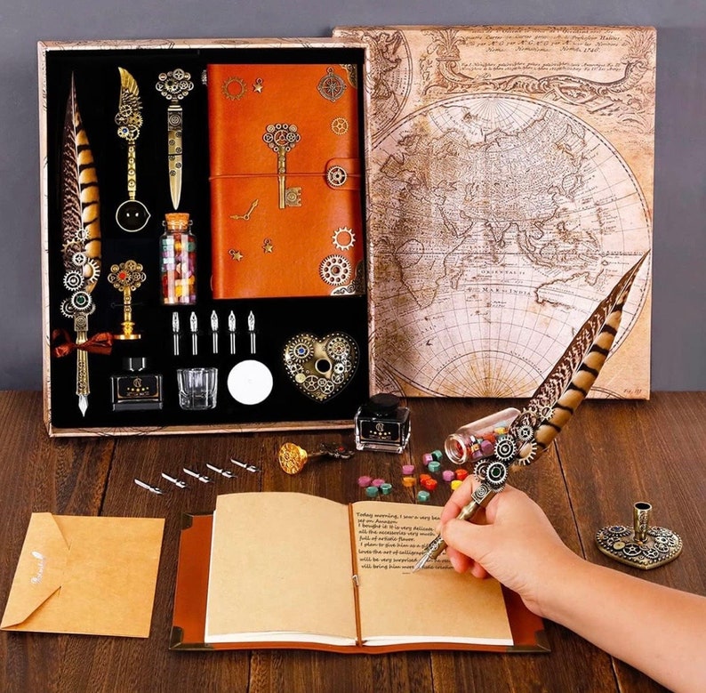 May include: A vintage-style calligraphy set in a wooden box with a leather-bound journal, inkwell, feather pen, and various nibs. The box also includes a wax seal and a decorative heart-shaped charm.