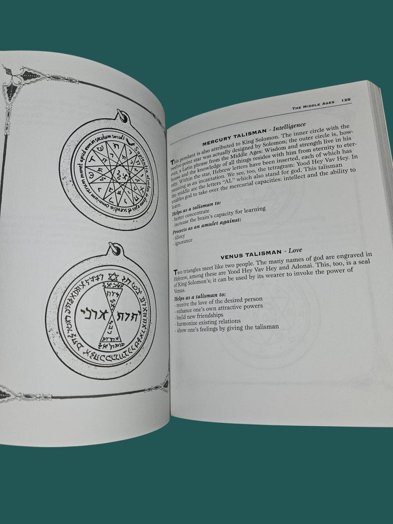 K&ouml;nnte beinhalten: Offenes Buch mit zwei detaillierten Illustrationen von Talismanen, die komplizierte geometrische Designs und Text aufweisen. Die Seite enth&auml;lt auch Text, der die Talismane beschreibt. Das Buch liegt auf einer gr&uuml;nen Oberfl&auml;che.