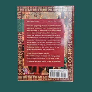 K&ouml;nnte beinhalten: Ein Buchcover mit rotem Hintergrund und goldenen Akzenten. Der Text enth&auml;lt "BODY/MIND/SPIRIT" und eine Beschreibung antiker Talismane und Amulette. Das Backcover enth&auml;lt auch Text von "The New Times" und "New Age Retailer".