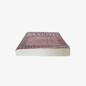 May include: A book titled "Enochian Magic in Practice" by Frater Yechidah. The book has a brown cover with a geometric design and text in a serif font. The book's pages are white, and the spine is visible.
