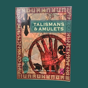 K&ouml;nnte beinhalten: Buchcover f&uuml;r "Talismans & Amulets" mit Vintage-Design. Das Cover zeigt eine Hand, geometrische Formen und Illustrationen in Rot-, Braun- und T&uuml;rkist&ouml;nen. Der Name des Autors, Felicitas H. Nelson, ist ebenfalls sichtbar.