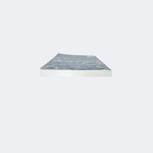 May include: A paperback book viewed from the side, showing the white pages and a cover with a dark, mottled gray and white abstract pattern. The title text Serpent Songs is printed in a light, thin font on the top cover surface.