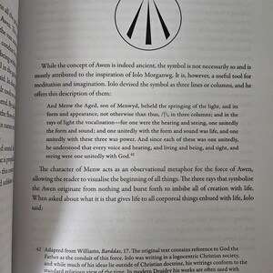 Op de afbeelding: Een open boekpagina met tekst en een cirkelvormig symbool. Het symbool toont drie zwarte lijnen die uitstralen vanuit een centraal punt, met drie stippen erboven. De tekst bespreekt Dru&iuml;derij en het concept van Awen.
