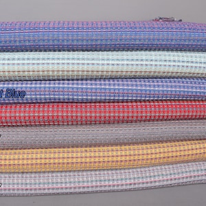 May include: A stack of seven waffle weave towels in various colors, including sax blue, mint, parliament blue, red, dark gray, mustard, and light gray. The towels are folded and stacked on top of each other.