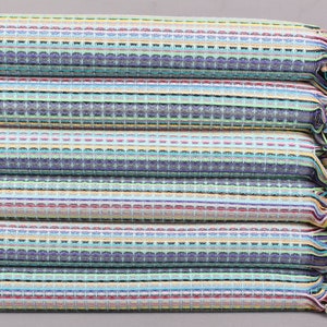 May include: A stack of colorful, striped waffle-weave towels. The towels feature a mix of blue, green, yellow, and red stripes. The edges have a fringe of matching colors. The towels are folded neatly.