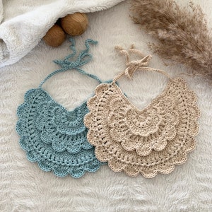 May include: Two crocheted collars, one in a light blue color and the other in a beige color. Both collars have a scalloped edge and are made with a delicate crochet stitch.