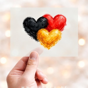Könnte beinhalten: Eine Karte mit vier Herzen in Schwarz, Rot und Gold, gehalten von einer Hand. Die Herzen sind mit Pinselstrichen gemalt. Die Karte zeigt die Website www.jeklu.de und Text am unteren Rand.