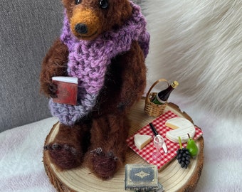 Needle felted Scruffy Bear character, wearing a hand knitted scarf with picnic of cheese and wine accessories