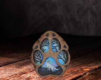 Quemador de incienso con forma de pata de lobo y escena de un lobo aullando.