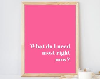 May include: A rectangular wall art print in a light wood frame featuring a vibrant hot pink background with the white text What do I need most right now? centered in the lower portion of the frame, presented in a clean, modern serif font.