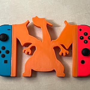 May include: A 3D printed orange Charizard figure with two blue and red Nintendo Switch Joy-Con controllers on either side.