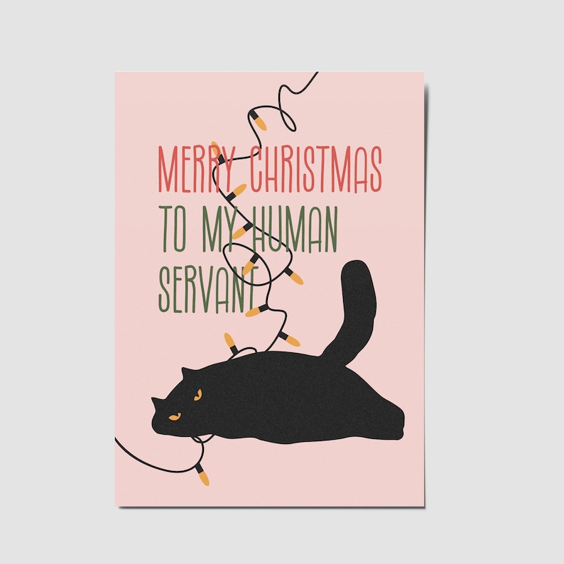 May include: A rectangular greeting card with a light pink background featuring a black cat silhouette tangled in a string of yellow Christmas lights. The text reads MERRY CHRISTMAS TO MY HUMAN SERVANT in red and green capital letters.