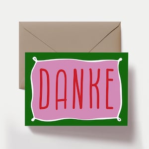 Peut inclure: Une carte de v&oelig;ux rectangulaire avec une bordure vert fonc&eacute; et un rectangle rose central dot&eacute; d'un contour blanc. Le mot DANKE est imprim&eacute; en lettres rouges, capitales et sans empattement au centre. La carte est accompagn&eacute;e d'une enveloppe beige.