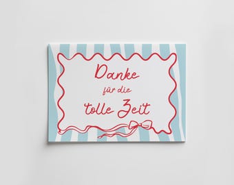May include: A rectangular greeting card featuring a light blue and white vertical striped background. The center has a white rectangular area with a wavy red border, red cursive text reading Danke für die tolle Zeit, and a red bow illustration.