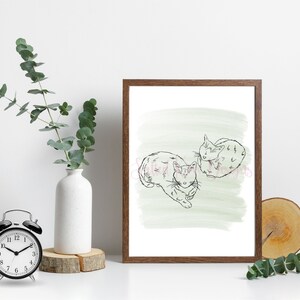 以下が含まれることがあります： 薄い緑色の水彩画の背景に、2匹の猫のミニマルな線画を描いた額装されたプリントです。