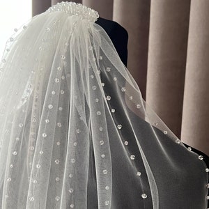 Puede incluir: Un velo de novia blanco de una sola capa con un borde de cuentas. El velo est&aacute; hecho de tul suave y presenta un delicado patr&oacute;n de peque&ntilde;as cuentas transparentes.