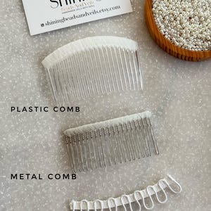 K&ouml;nnte beinhalten: Draufsicht auf drei Brautschleier-Komponenten: ein durchsichtiger Plastikkamm, ein silberner Metallkamm und wei&szlig;e Schlaufen. Eine Visitenkarte und eine Schale mit Perlen sind ebenfalls zu sehen. Der Text "Shining Beads And Veils".