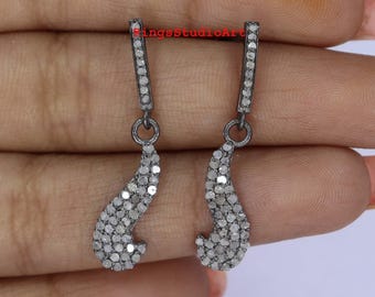 May include: A pair of dangle earrings with a dark gray metal finish. Each earring features a rectangular top with a row of small, clear stones, connected to a curved, teardrop-shaped bottom also covered in small, clear stones. The earrings are displayed against a light background.