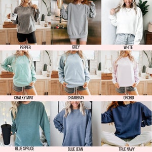 May include: A collection of long-sleeved sweatshirts in various colors, including pepper, grey, white, chalky mint, chambray, orchid, blue spruce, blue jean, and true navy. Each sweatshirt is displayed on a person.