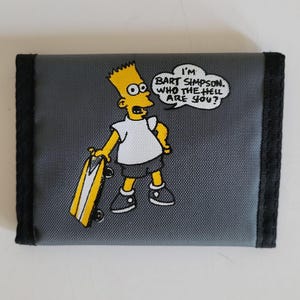 May include: Gray wallet featuring Bart Simpson with a skateboard. Bart is depicted in his signature yellow skin, white shirt, and blue shorts. A speech bubble says, "I'm Bart Simpson, who the hell are you?" The wallet has black trim.